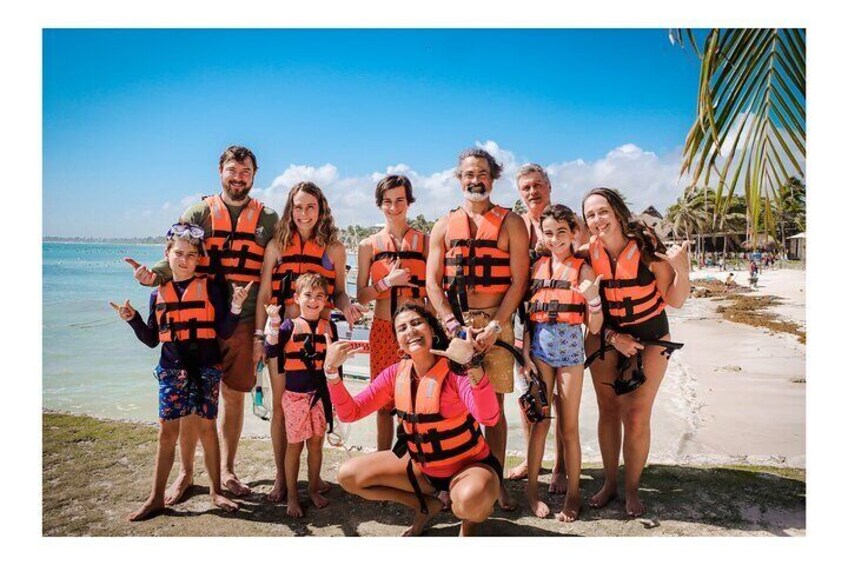 A group of people on a beach wearing life jackets. 4