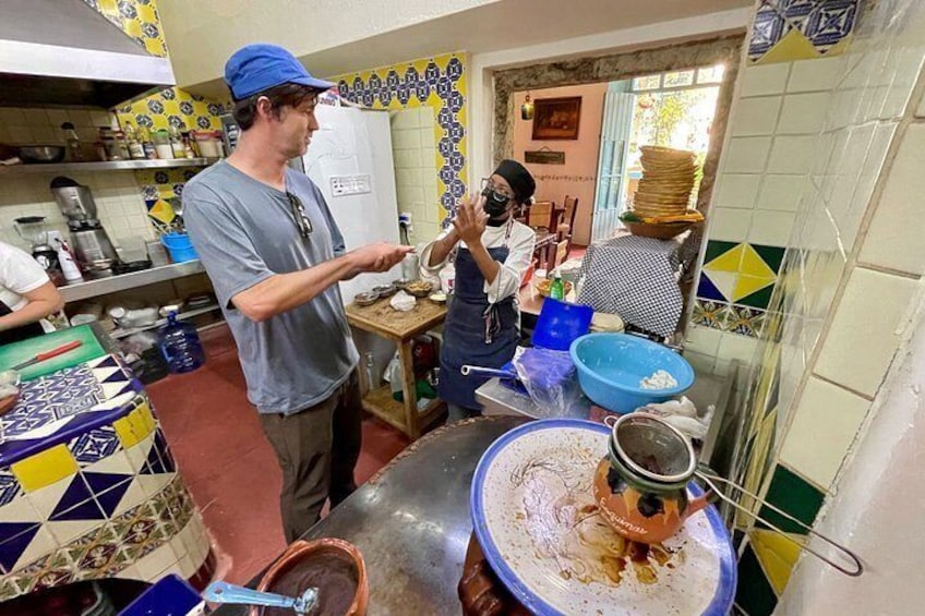 A kitchen with tiled walls, a large metal pot, and a blue bowl on a counter. 3