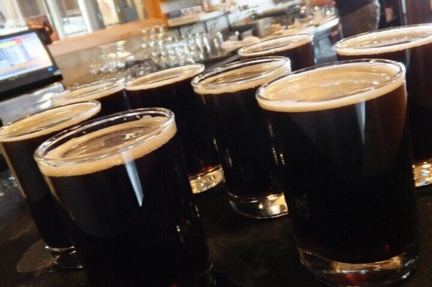 Plusieurs verres de bière brune, avec une mousse crémeuse sur le dessus. 2