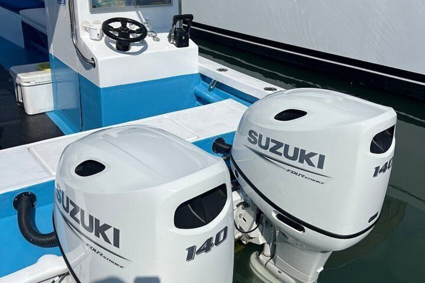 Two Suzuki outboard motors mounted on a boat. 4