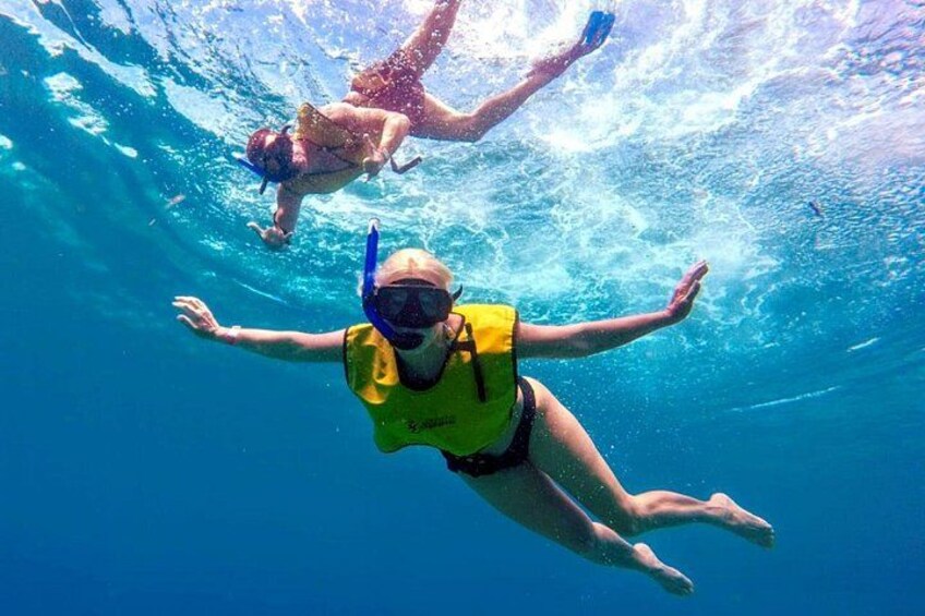 To personer snorkler under vandet i krystalklart, blåt vand. 5