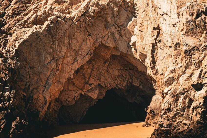 A large rock formation with a cave entrance. 3