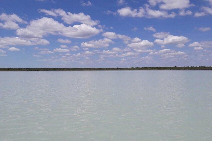 Un cuerpo de agua tranquilo con cielo despejado y algunas nubes. 2
