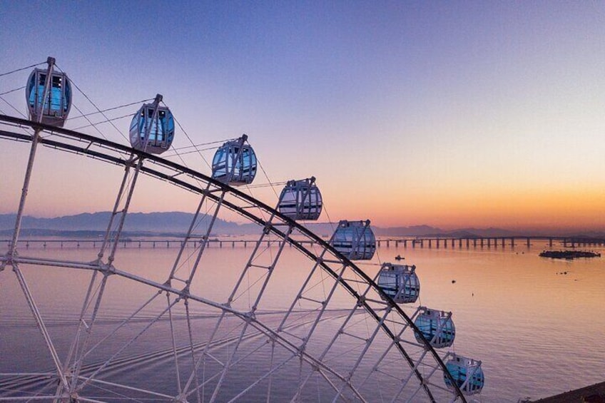 Sistema de teleférico al atardecer, con un puente en el fondo. 2
