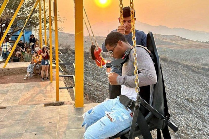 Una persona en un columpio con un atardecer de fondo. 4