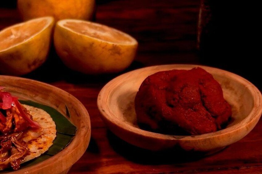 Un bol en bois contenant une substance rouge, un bol en bois contenant une substance jaune et une assiette en bois avec de la nourriture. 2