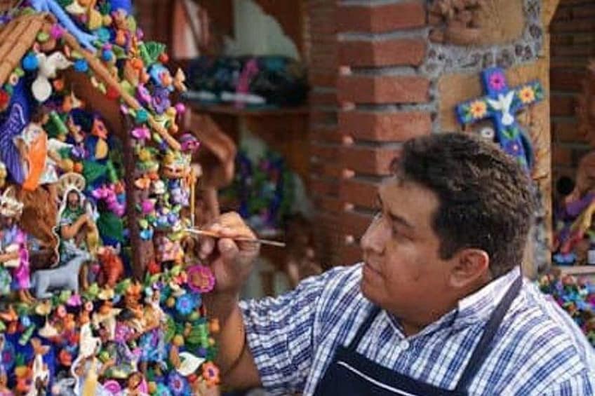 A person crafting with colorful beads and feathers. 2