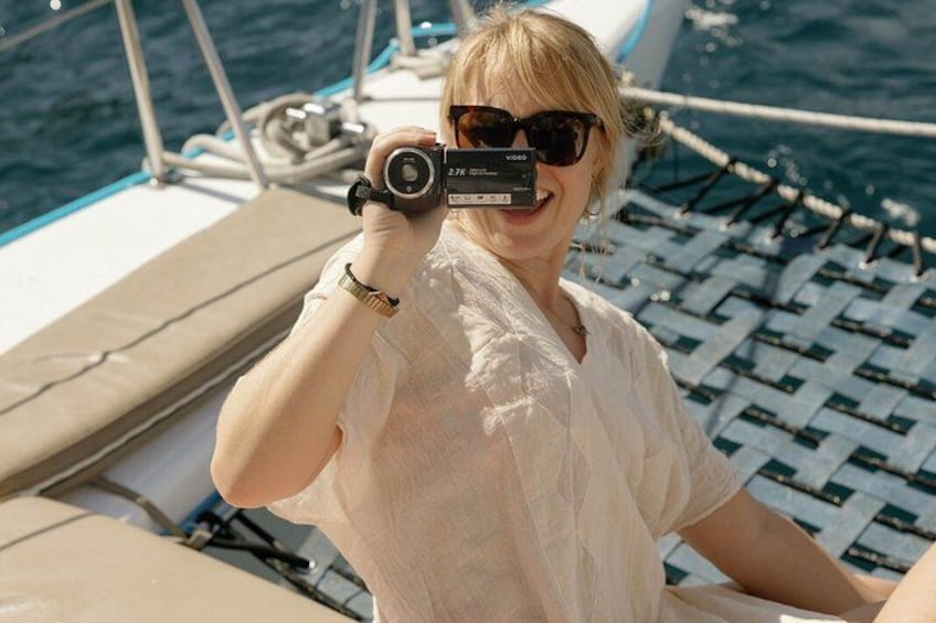 A person on a boat, holding a camera. 2
