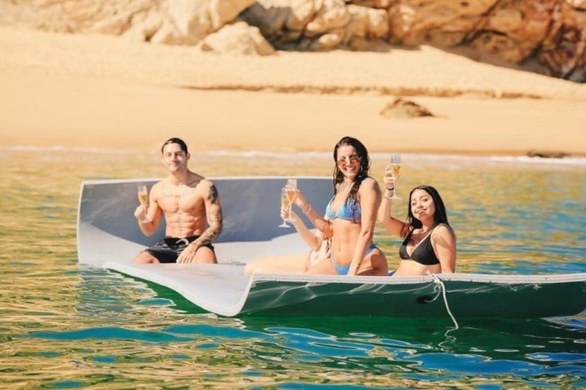 Una pequeña embarcación sobre aguas tranquilas, con una playa arenosa y rocas al fondo. 5