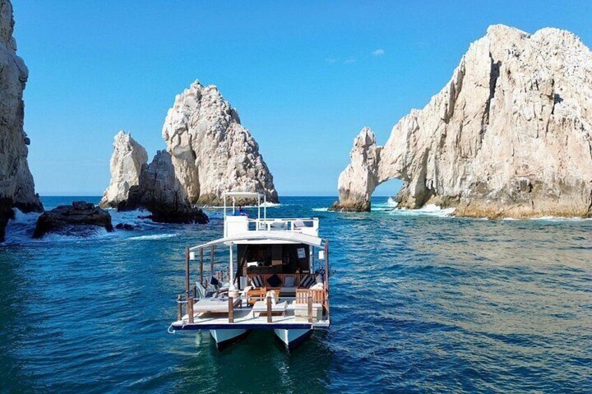 A boat on calm waters with two large rock formations in the background. 3