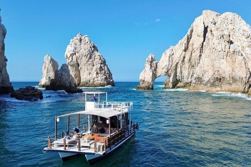 A boat on calm waters with rocky formations in the background. 2