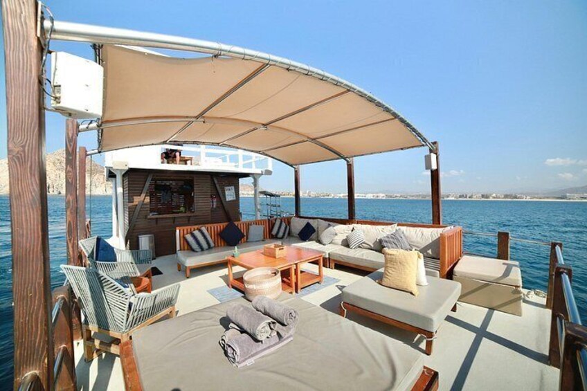 A boat with a covered seating area, a bar, and a view of the sea. 4