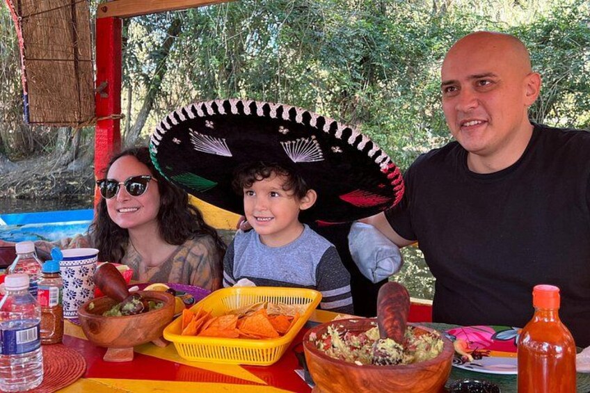 A family at a picnic with food and drinks on a table. 3