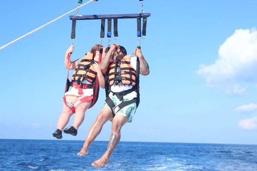 Dos personas haciendo bungee jumping desde una plataforma sobre el océano. 2