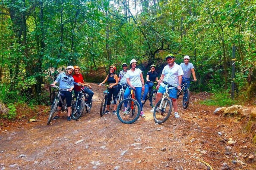 En gruppe mennesker cykler på en sti i en skov. 5