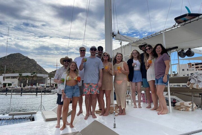 A group of people on a boat, a marina, and a mountainous landscape in the background. 2