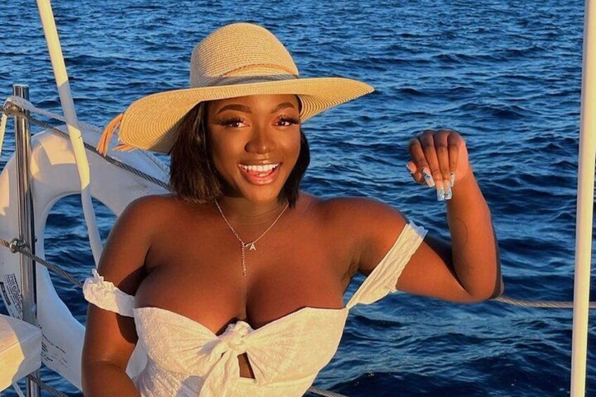 A person on a boat with a lifebuoy, wearing a straw hat and a white top. 3