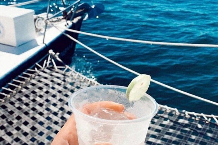 A hand holding a plastic cup with a slice of lime on a boat. 4