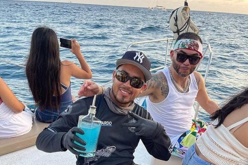 A group of people on a boat with a man holding a bottle. 4
