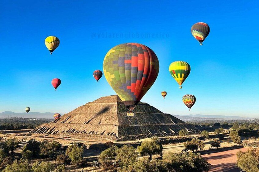 Una pirámide grande con globos aerostáticos al fondo. 2