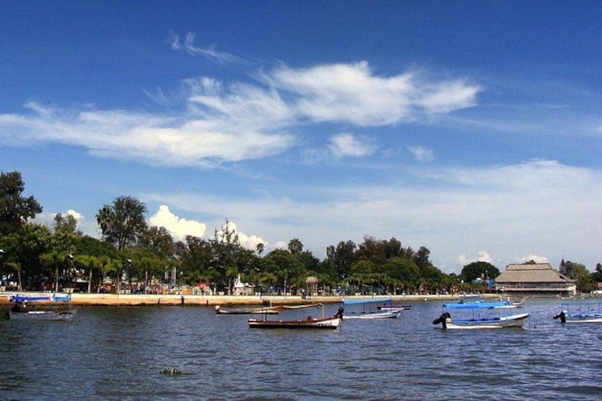 A waterfront with boats, a beach, and a large building in the background. 1