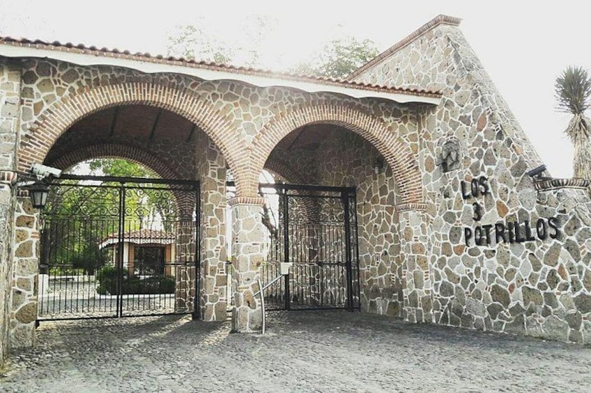 A stone building with arched entrances and a gate, labeled 'LOS 3 POTRillos'. 4