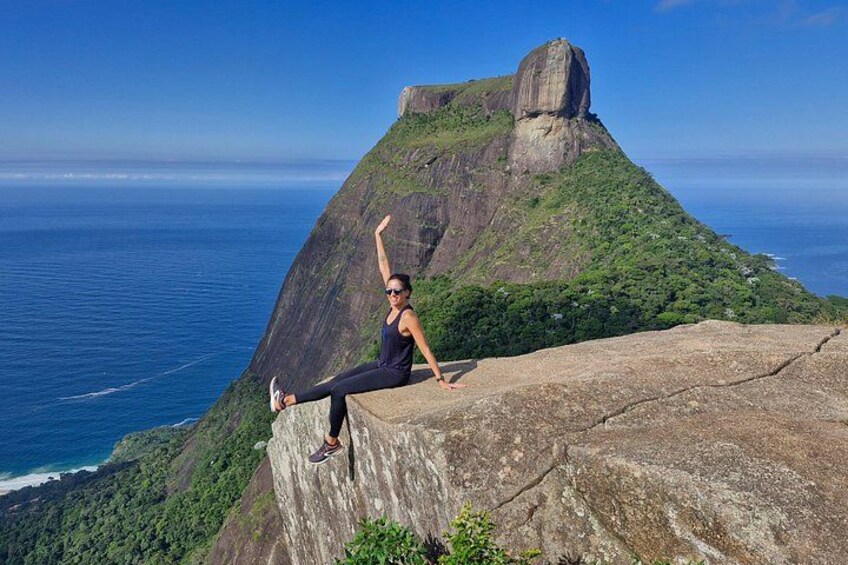 A person performing a yoga pose on a cliff overlooking the ocean. 1