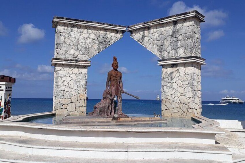 A statue of a warrior in a stone archway by the sea with a yacht in the background. 3