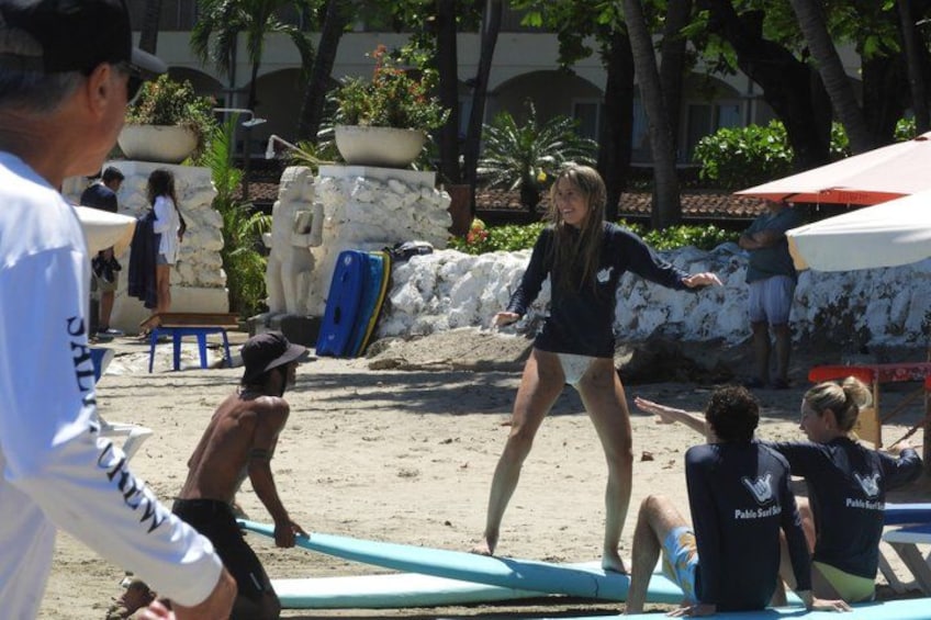 A beach with people, surfboards, and a lifeguard tower. 2