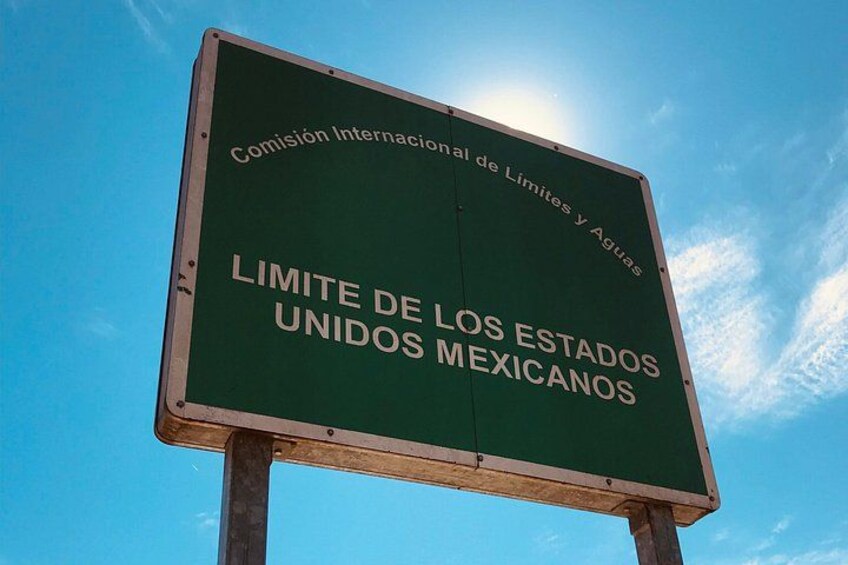 A green sign with white text against a clear blue sky. 3