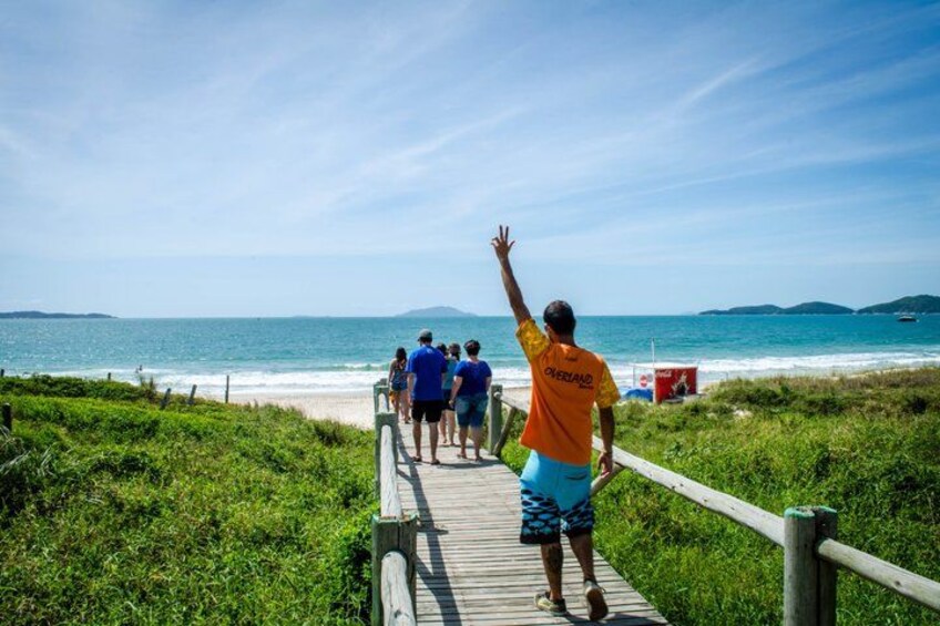 A wooden boardwalk leading to a beach with people walking. 4