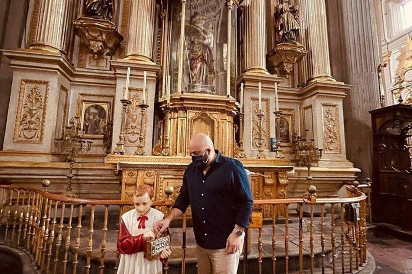 A man and a child in a church with ornate altars and statues. 3