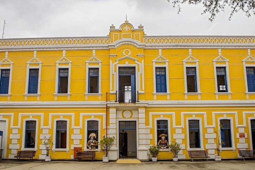 A yellow building with blue windows and a central entrance. 2