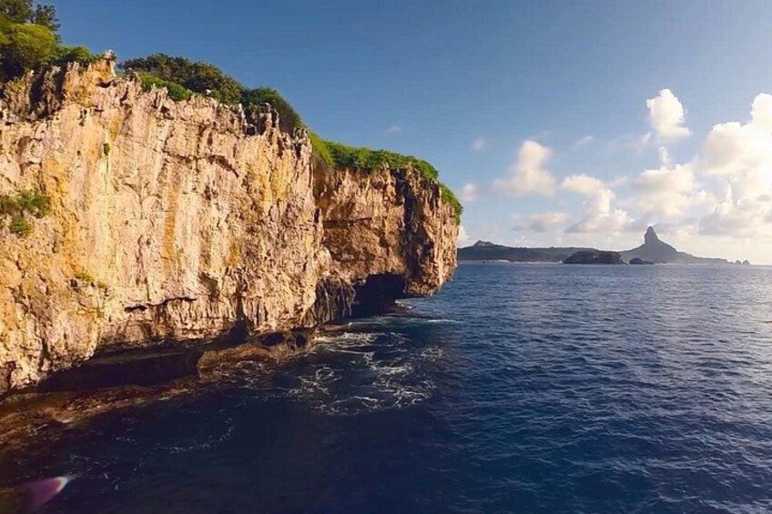 A coastal cliff with a rocky surface and a body of water. 2