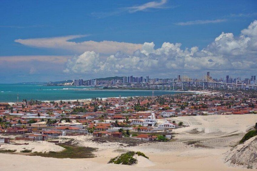 Un paisaje urbano costero con playa, zona residencial y un puente destacado. 3