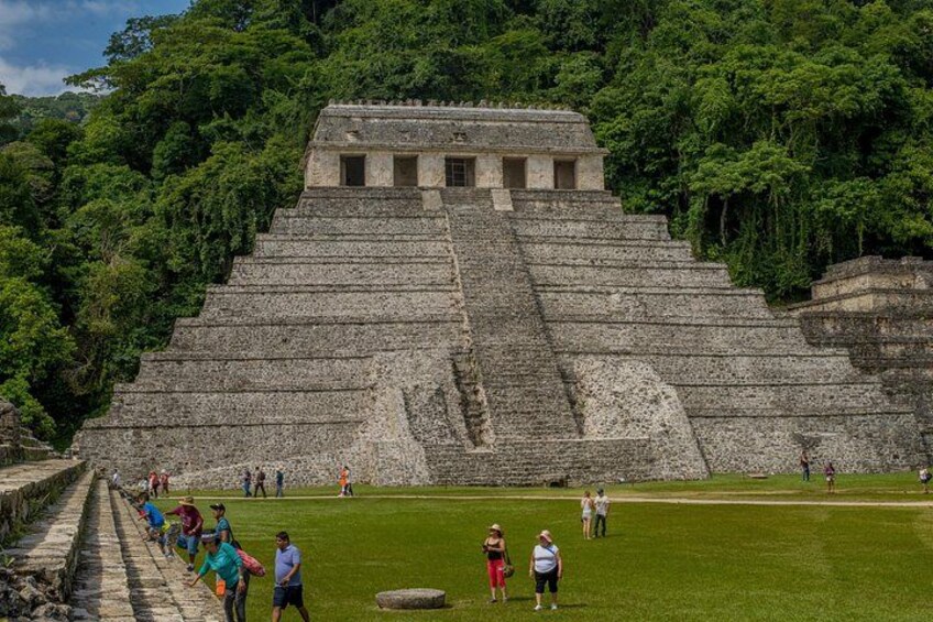 A large pyramid structure surrounded by lush greenery. 2