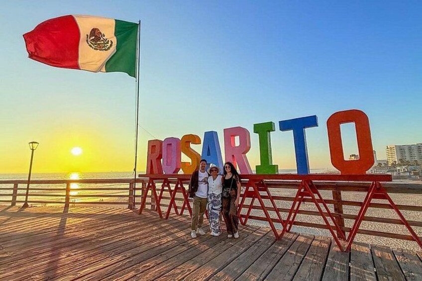 En træpromenade med et stort skilt, der staver 'NUSARITO', og et mexicansk flag i baggrunden. 2
