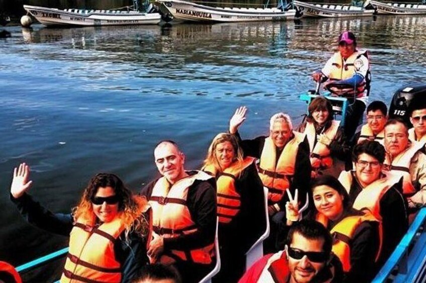 A group of people on a boat wearing life jackets. 3