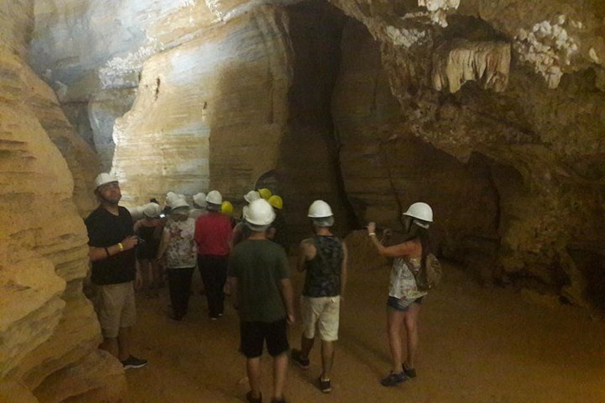 A group of people in a cave with stalactites. 2