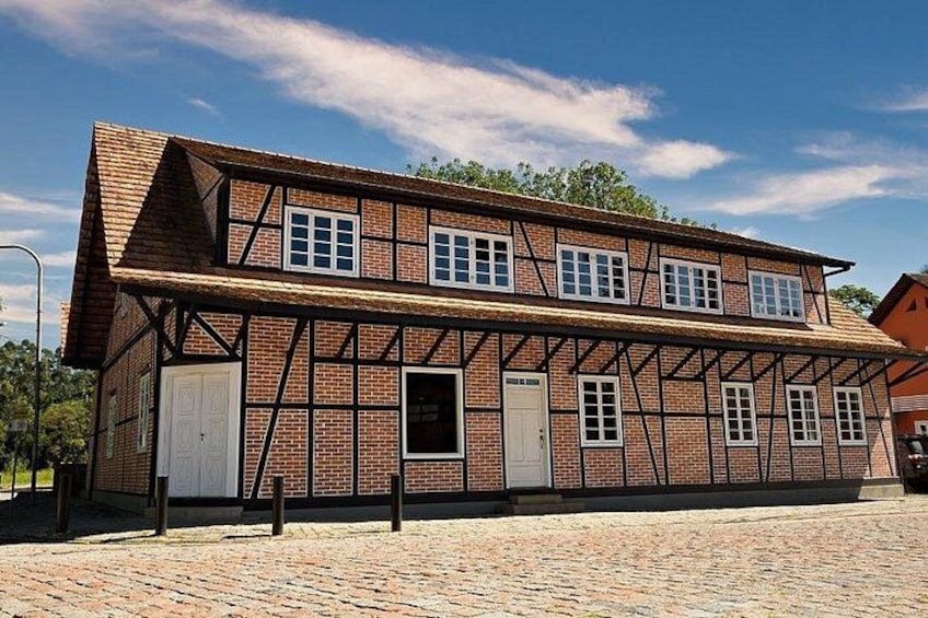 A traditional half-timbered building with a sloped roof, multiple windows, and a brick facade. 3