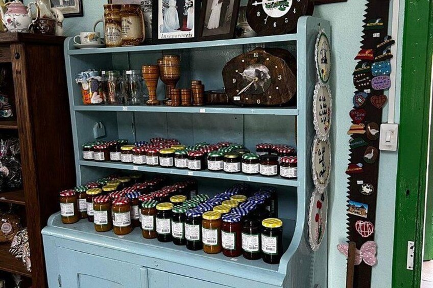 A shelf with jars of preserves and a clock. 1