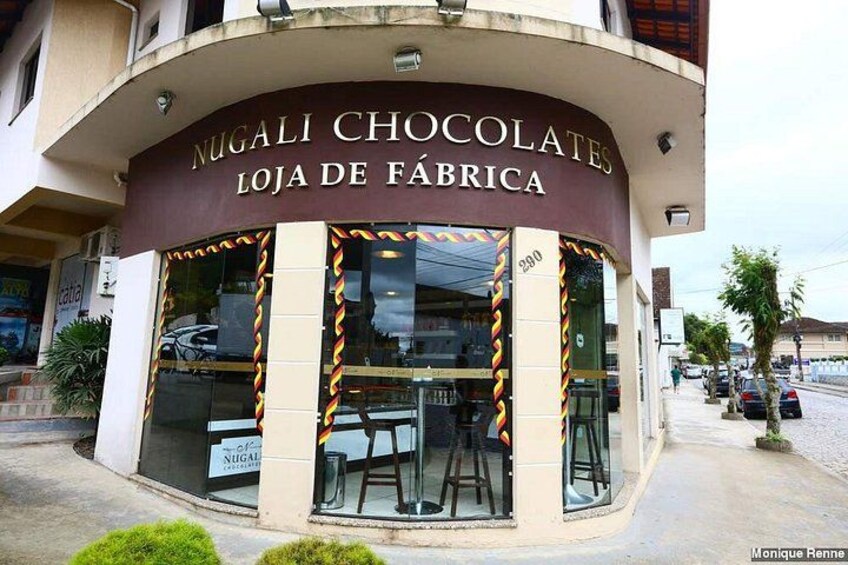 A chocolate shop named 'Nugali Chocolates' with a curved facade and large windows. 3