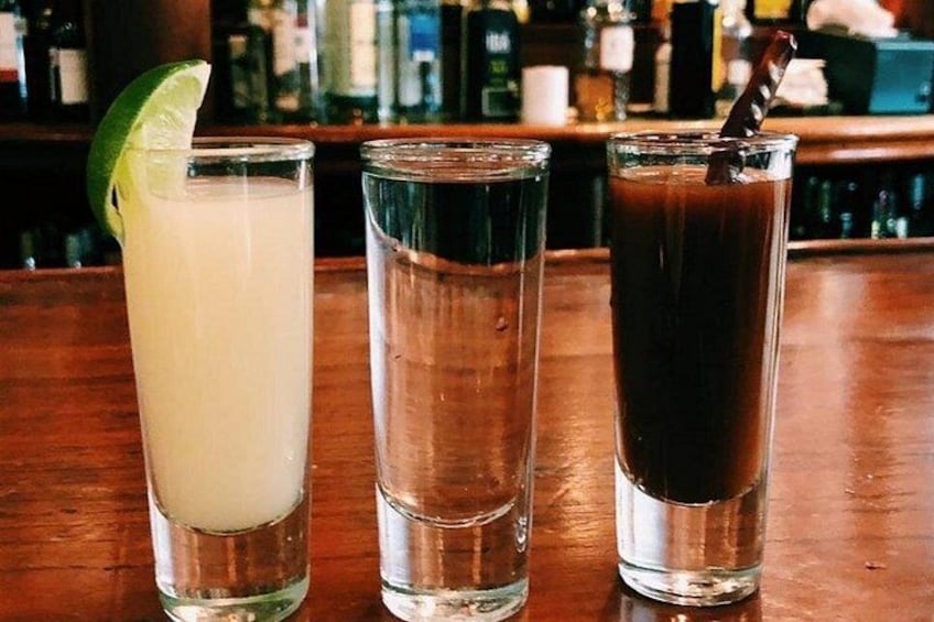 Three glasses of different beverages on a bar counter. 1