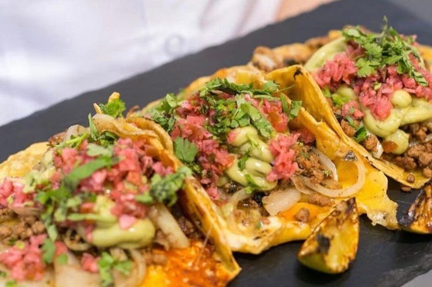 A plate of tacos with meat, onions, and cilantro. 2