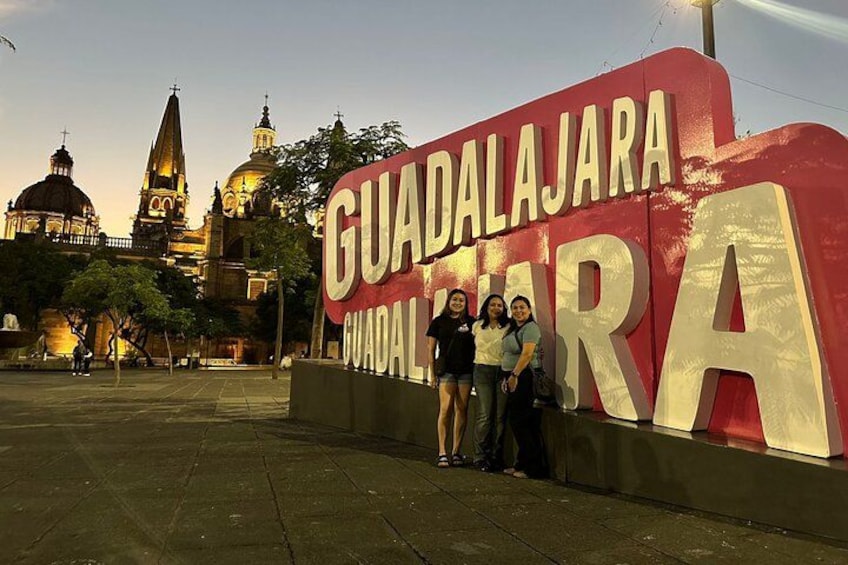 Une grande enseigne sur laquelle on peut lire « GUADALAJARA », avec une vue de la ville en arrière-plan. 4