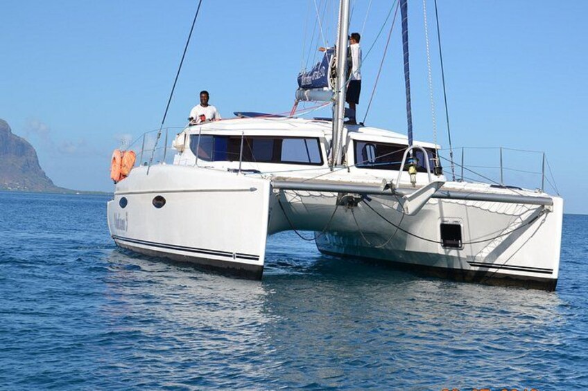 Un yate de vela blanco con camarote y una persona de pie en la cubierta. 2