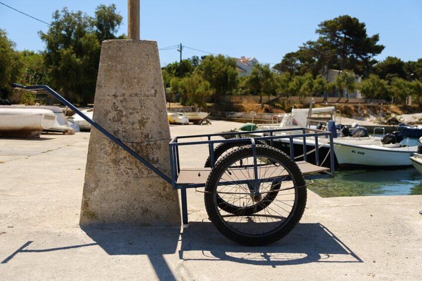 A concrete structure, a bicycle with a basket, and a row of boats at a marina. 4