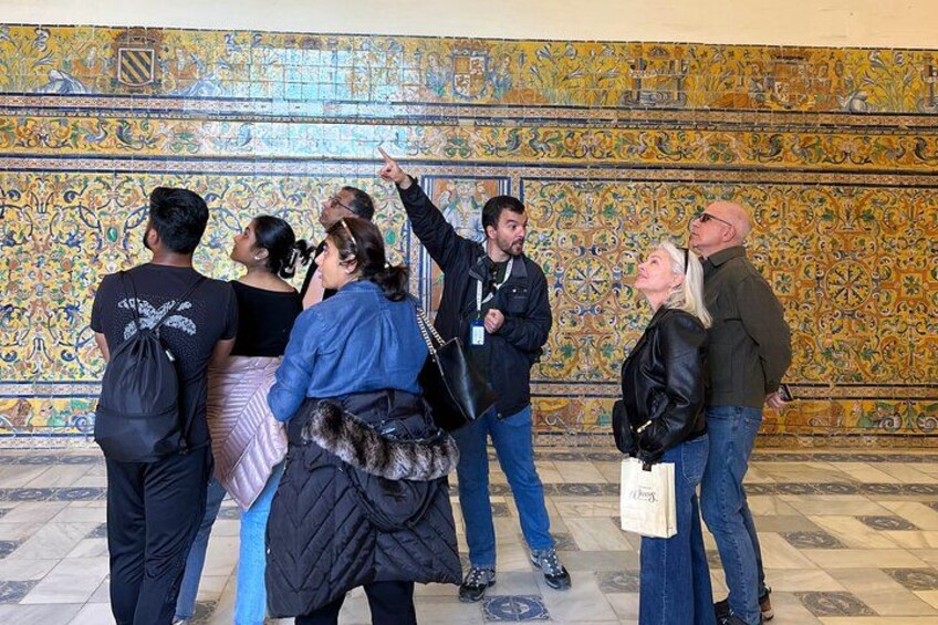 Un grupo de personas frente a un muro con diseños intrincados. 3