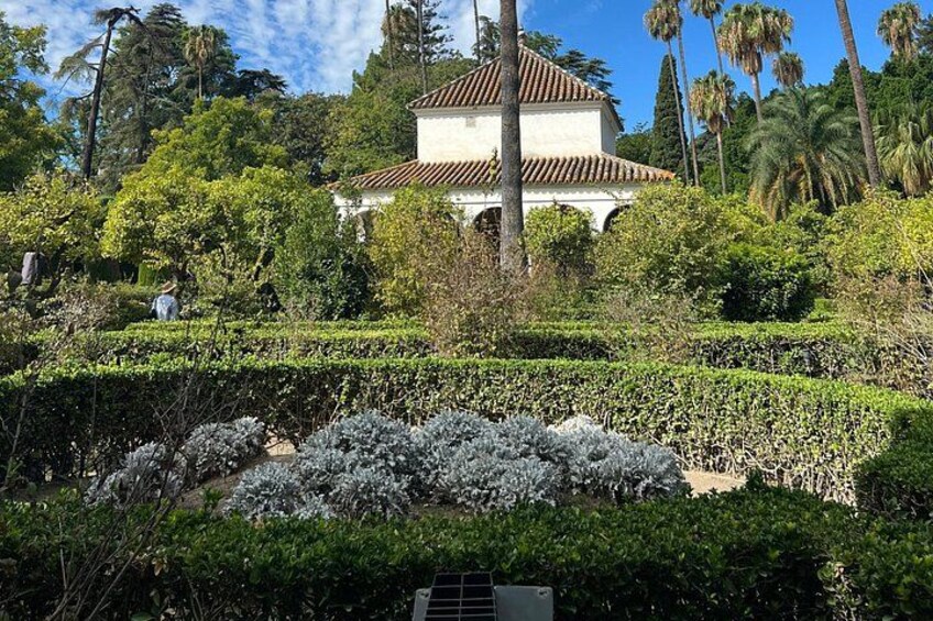 Un edificio tradicional rodeado de abundante vegetación y un jardín bien cuidado. 2