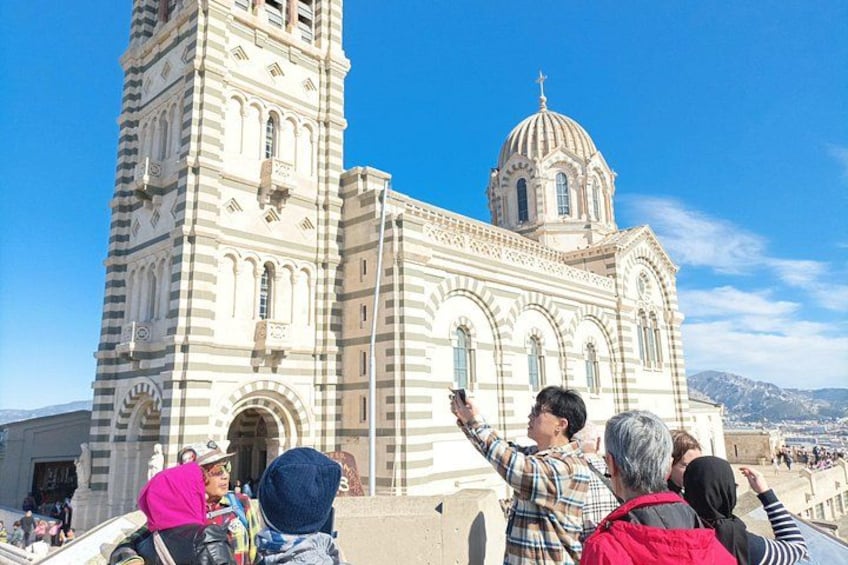 Une église historique, dotée d’un haut clocher et d’une coupole, entourée de touristes. 1